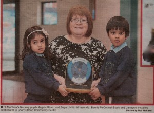 St. Matthew's Nursery uvulas Angela Khatri and Boga Likhith Vihaan with Nerie Mcconnell-Black and the newly installed defibrillator in Short Strand Community Centre. Picture Mal McCann Irish News.